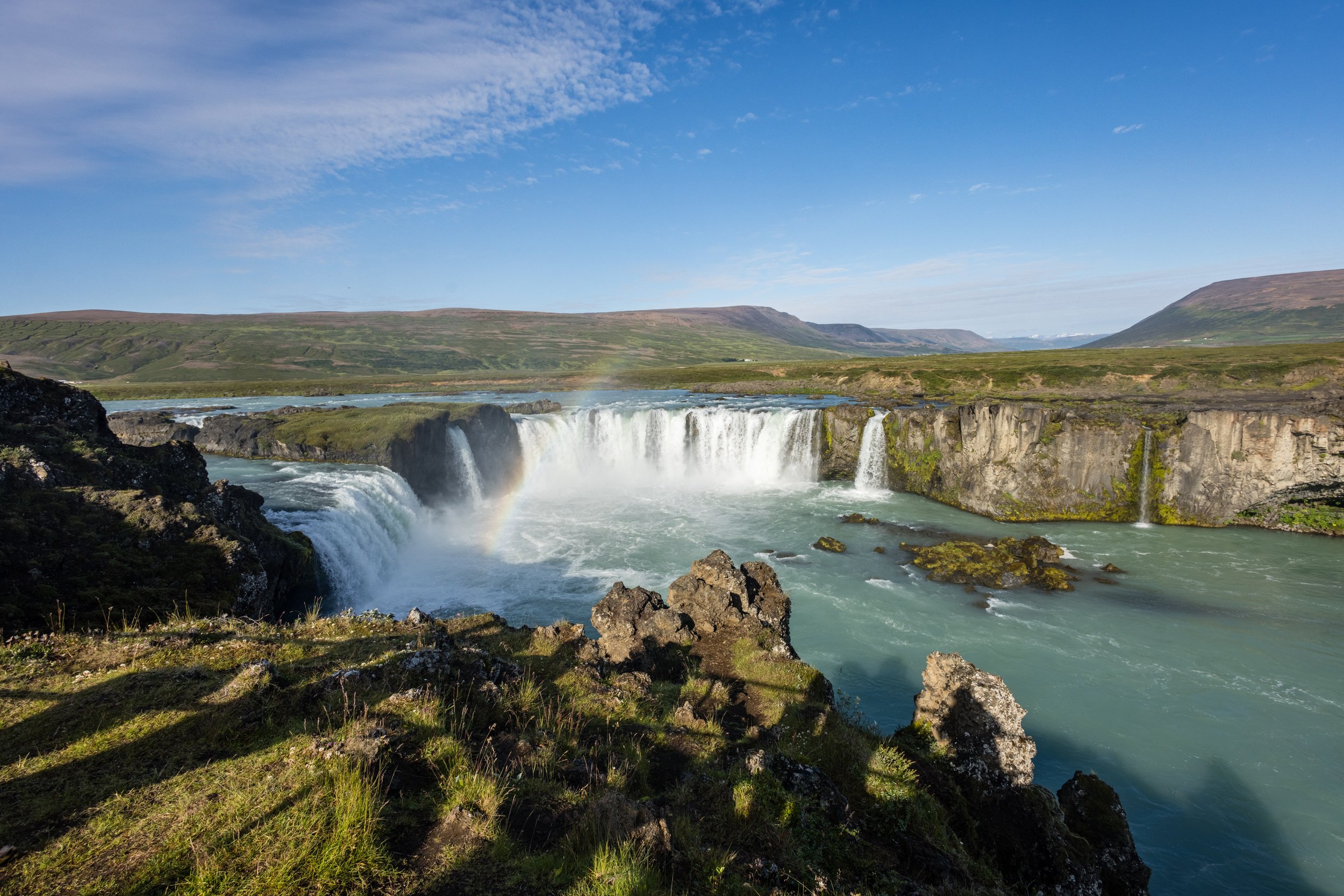 Goðafoss waterfall plunging into a gorge, spray rising over basalt cliffs, Iceland