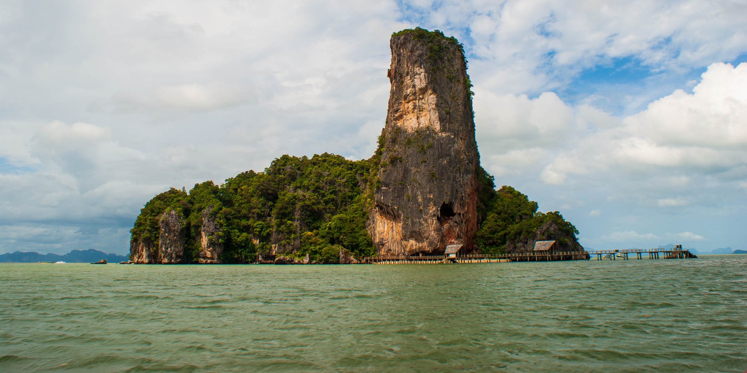 Tropical shoreline silhouettes and long-tail boats, Thailand